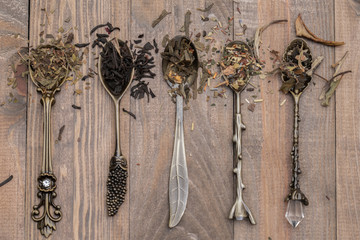Dried black and green tea leaves on vintage spoons