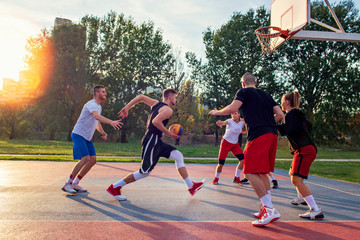 Fototapeta premium Group Of Young Friends Playing Basketball Match