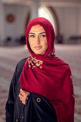 Young muslim woman reading Quran in the mosque and sunlight falling from the window