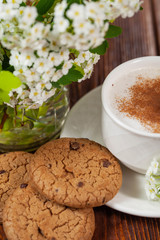 Cup of cappuccino with cinnamon and chocolate chip cookies