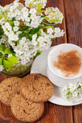Breakfast with a cup of cappuccino with cinnamon and chocolate chip cookies