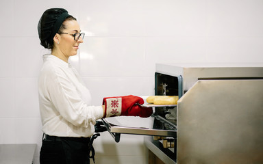 Cook of a restaurant preparing bread in the oven. Coffee shop