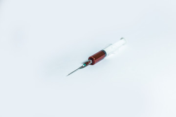 Syringe with blood on white background.