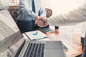 Business Meeting agreement Handshake concept, Hand holding after finishing up dealing project or bargain success at negotiation over office background.