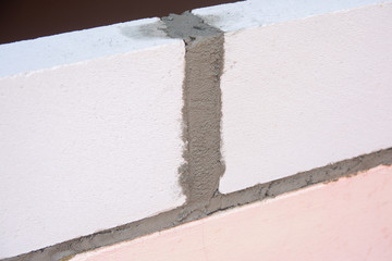 Bricklayer worker installing Lightweight Concrete on exterior wall with trowel putty knife.
