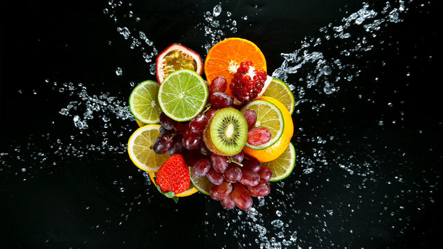 Super Slow Motion Shot of Fresh Fruits with Splashing Water Isolated on Black Background.