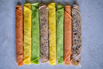 Pancakes of different color. Spinach, beetroot powder, blueberry and turmeric crepes.