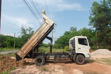 Dump truck unloading soil at construction site. © Achira22