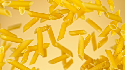 flying uncooked italian pasta penne on gold background, freeze motion.