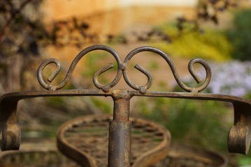 old brown decorative iron bicycle steering wheel with forged pattern on a colored background on the...