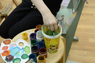 artist paints a picture of oil paint brush in hand