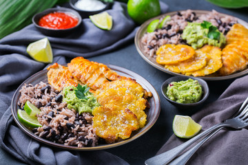 Rice with black beans, fried chicken breast and tostones, plantains