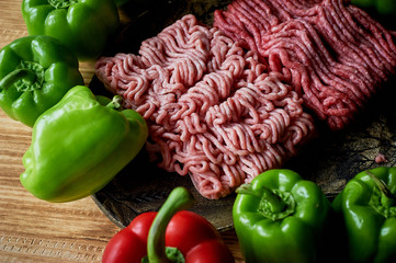 Mince and peppers. Ingredients for stuffed peppers. Two types of minceand and bell pepper. On a wooden background.