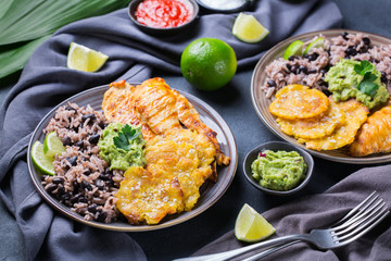 Rice with black beans, fried chicken breast and tostones, plantains
