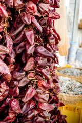 red dry hot chili peppers hanging on the market for sale. Concept of street trade in spices
