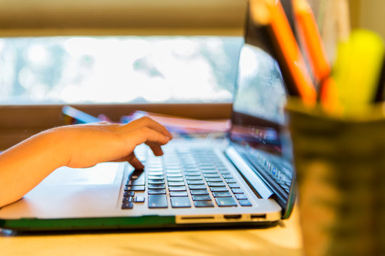 6 year old boy typing on a laptop computer at home