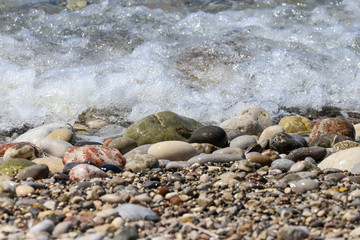 Close-up of ocean water flowing over pebble stone beach