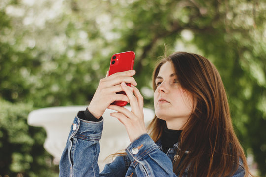 girl takes pictures with a mobile phone in a park