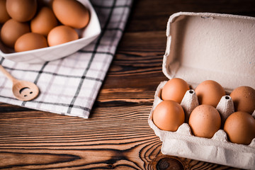 Detail close-up of chicken eggs on the old brown wooden background.