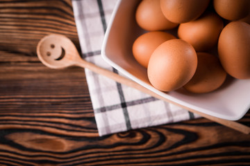 Detail close-up of chicken eggs on the old brown wooden background.