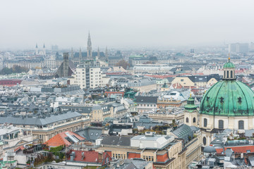 Fototapeta premium Cityscape of the old town of Vienna in a heavy snowy day. View at the tower of St. Stephen's Cathedral in Vienna, Austria.