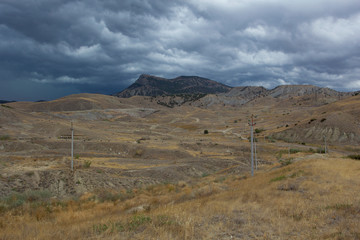 Fototapeta na wymiar View of the rain clouds over the mountains. Gathering storm, dramatic scene. Sun Valley, Crimea.