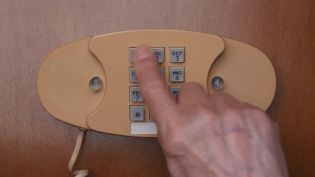 Top View Elderly Man Dialing 911 Number Buttons On Retro Push Dial Telephone. Making Phone Call On Vintage Wired Landline Phone..