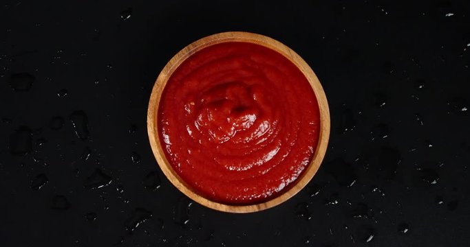 Homemade tomato sauce on plate slowly rotates.