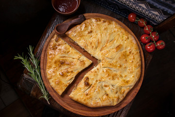 Hospitable Georgian cuisine. Khachapuri with meat on a wooden background