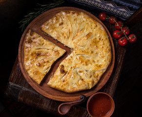 Hospitable Georgian cuisine. Khachapuri with meat on a wooden background