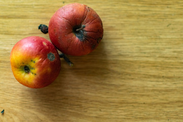 Bright juicy fruits, natural and natural fruits with damage. Red apples and tangerines on a modern brown light table