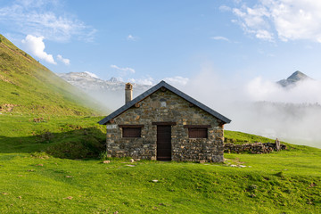 Fototapeta na wymiar Mountain shelter with a chimney in Pirineos in a foggy day