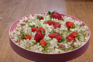 Fresh and juicy strawberries amid acacia flowers