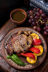 grilled steak with greens in a round ethnic plate. Georgian cuisine