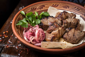 Grilled meat on pita with pickled onions and herbs