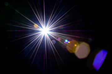 Obraz premium Flare background. Sunlight ray flash effect on black. Star spot or sun shine glow light on lens. Gleams rounded and hexagonal shapes, rainbow halo.