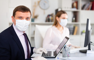 Portrait of businessman in protective medical mask at office