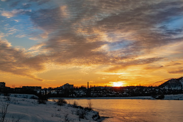 The colorful sky at sunset on a clear day plays with several colors , contrasting and rich beautiful view of the glow near the mountain and the city in winter