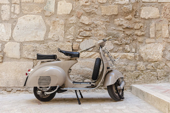 Fototapeta Gaeta, Italy. An old scooter parked in a narrow street in the historic center of Gaeta.
