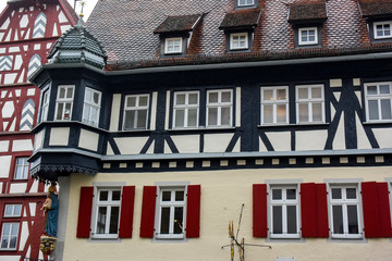 Obraz premium Traditional half-timbered houses on narrow medieval street in Rothenburg ob der Tauber, Bavaria, Germany. November 2014