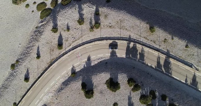 Car speeds along narrow mountain road in southern France