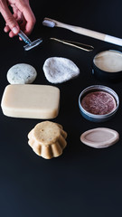 A woman's hand picks up a metal blade between various ecological objects