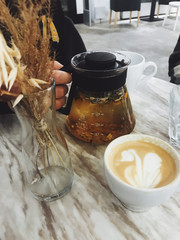 tea and a cup of coffee on a table in a coffee shop