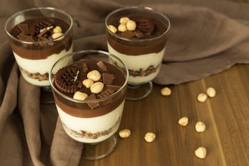 Service chocolate magnolia dessert with hazelnut on the wooden background.