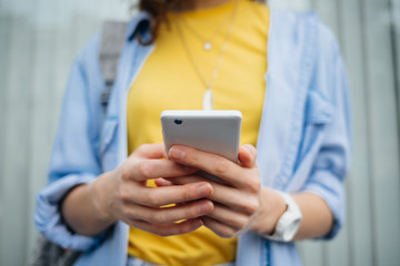 Close-up hands of young woman holding mobile phone