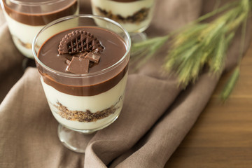 Service chocolate magnolia dessert with hazelnut on the wooden background.