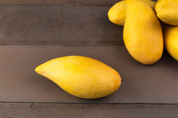 Yellow Fresh mangos real wood table. Mango tropical fruit on wood background. mangos with copy space for text or design.