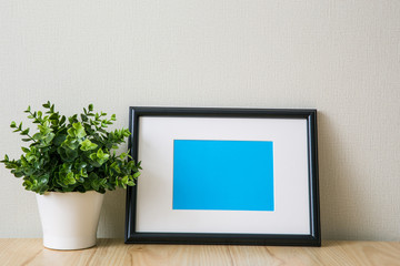 Mockup of a black photo frame with Passepartout. The light interior in the Scandinavian style
