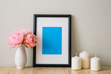 Mockup of a black photo frame with Passepartout. The light interior in the Scandinavian style