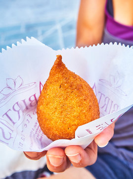 Istanbul, Turkey - July 8, 2018. A female hand holding a Icli Kofte, a traditional dish of the Arab cuisine. Also known as Kibbeh, Kibbe, Kibe or Quibbe depending on Middle Eastern region.